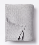 Averylily pure cotton matelassé coverlet. Each coverlet features a herringbone design that is unique to Averylily. Shown here in Stone Grey.
