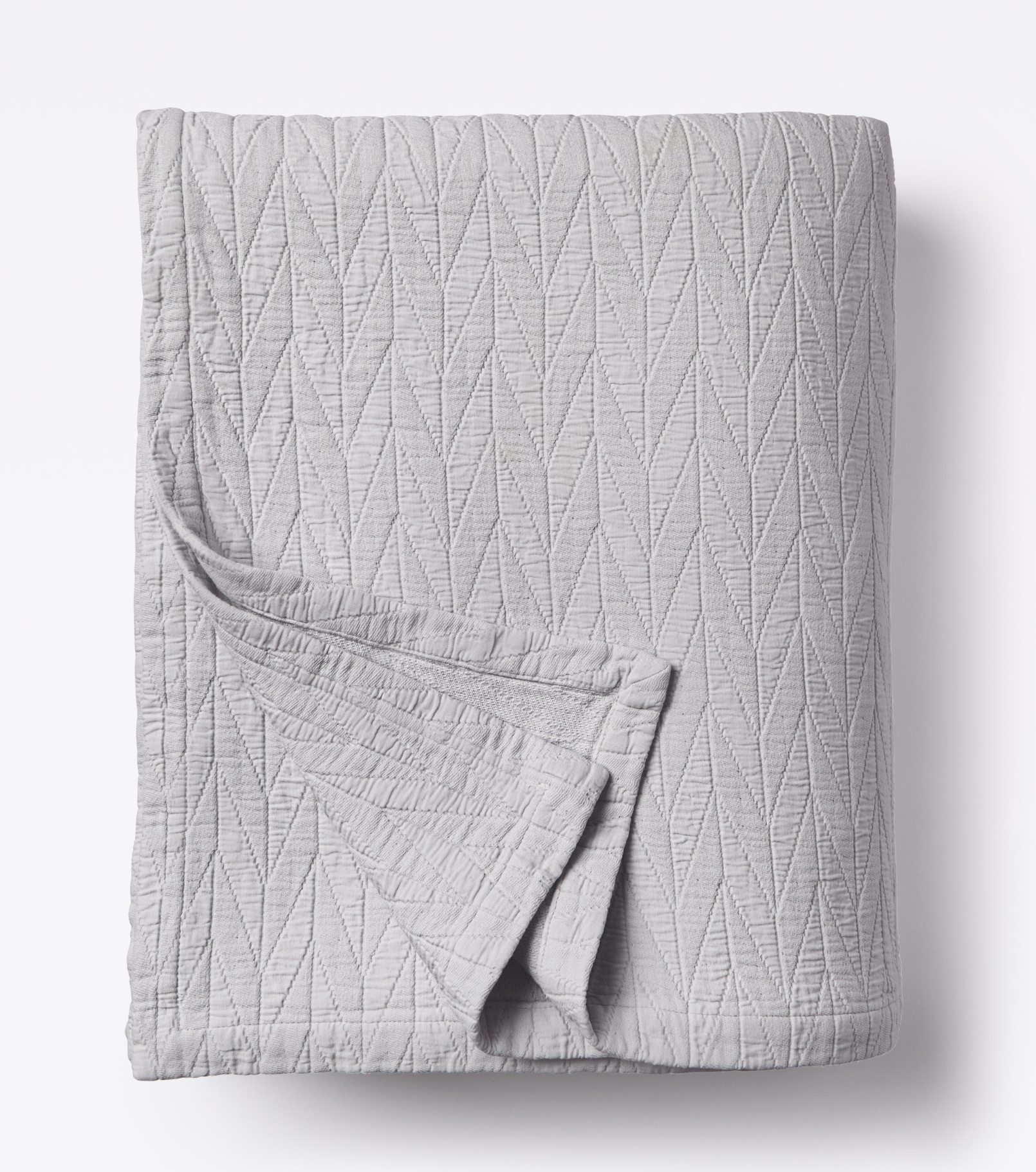 Averylily pure cotton matelassé coverlet. Each coverlet features a herringbone design that is unique to Averylily. Shown here in Stone Grey.