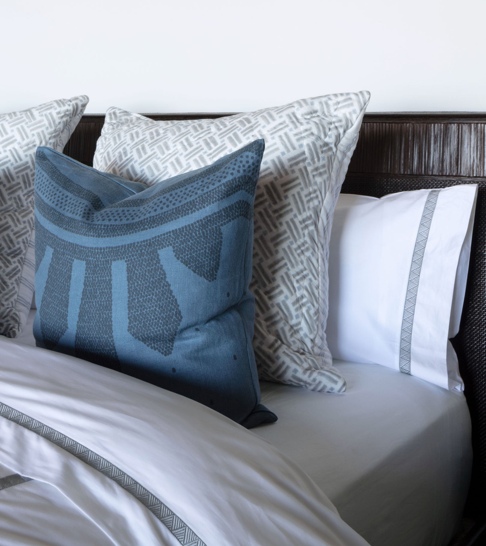 Averylily Weave Duvet Cover in White with embroidered trim in Stone Grey. 510-thread count cotton percale. Styled with Averylily Big Island Euro Shams in Driftwood and Ocean andSerena Dugan Studio decorative pillows.